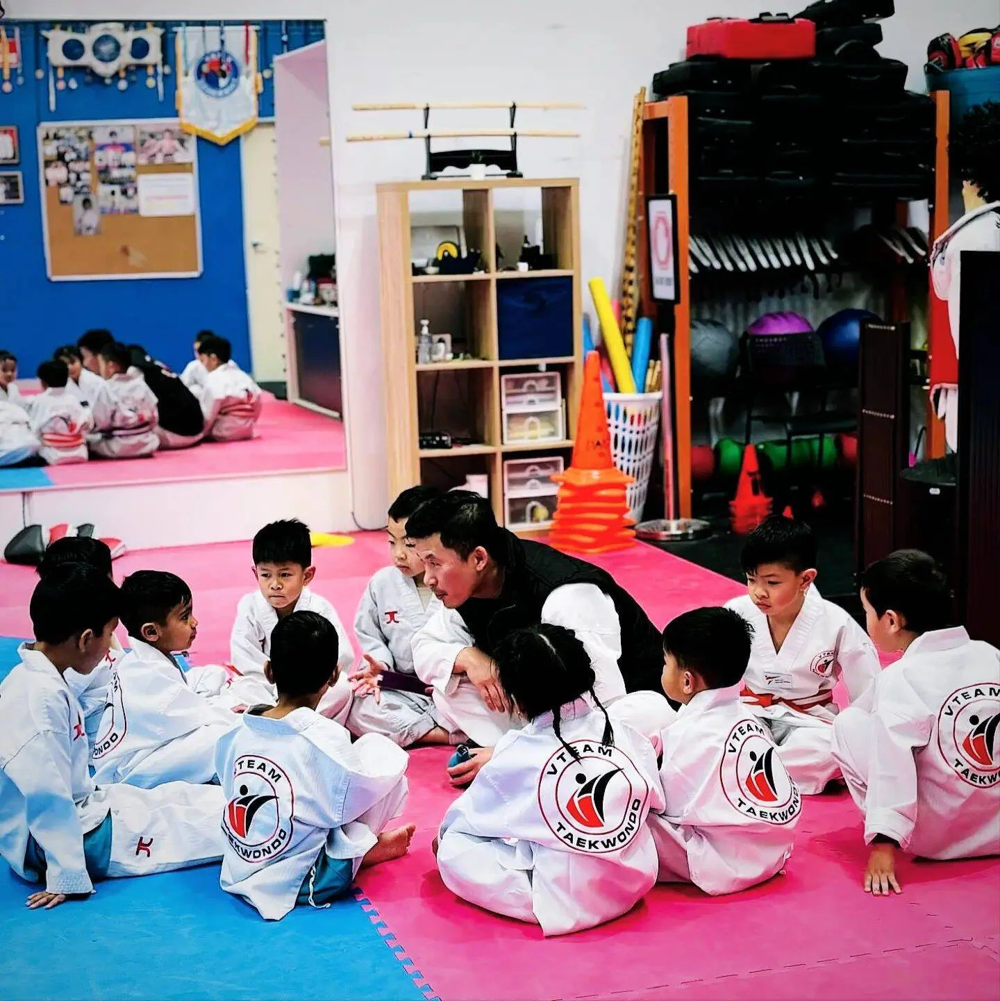 Young students sit in a circle with Master Eric
